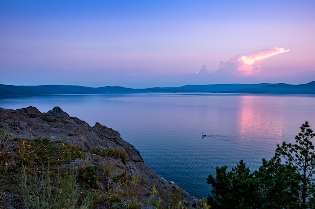 Lago escénico y costa rocosa después del atardecer