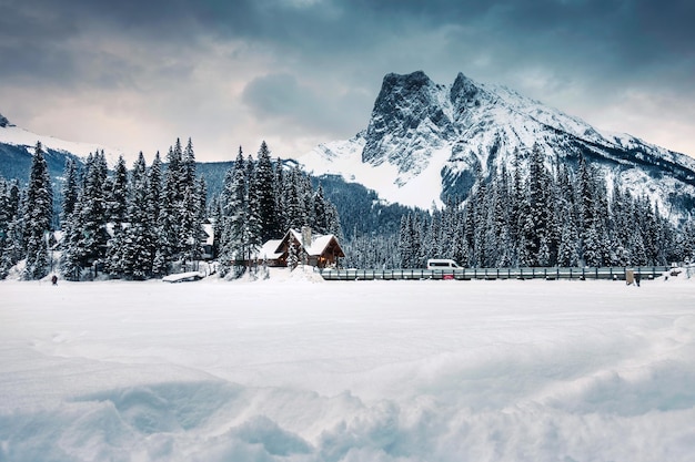 Lago Esmeralda con cabaña de madera y montañas rocosas cubiertas de nieve en invierno en el parque nacional Yoho