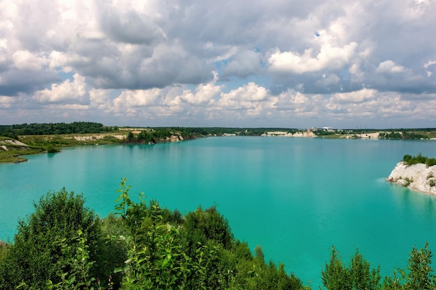 Lago inusual con agua turquesa en la cantera de tiza Cantera de tiza rocosa de la costa pedregosa en un día soleado de verano