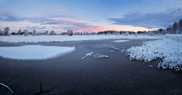 Lago de invierno cubierto de hielo y nieve al atardecer. West Lothian, Escocia, Reino Unido