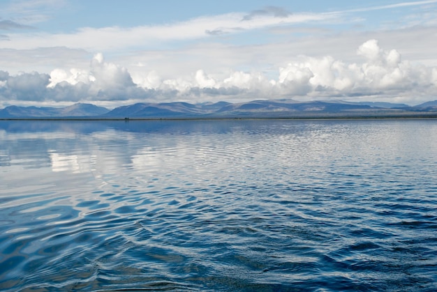 Lago lama com uma cadeia de montanhas