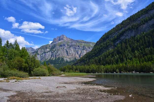 Foto lago de montaña con agua clara y cielo azul con nubes en verano