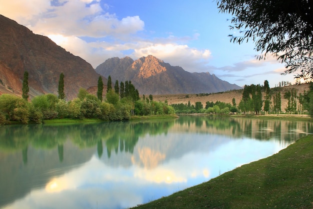 un lago con una montaña al fondo y una montaña en el fondo