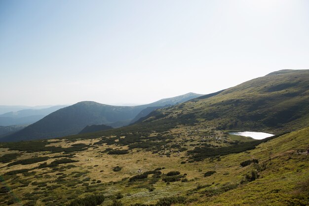 Lago de montaña en lo alto de las montañas verdes