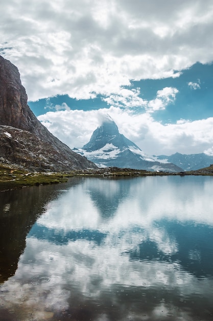 Lago de montaña Matterhorn con reflejo de agua hierba y piedras Zermatt Alpes Suizos Suiza