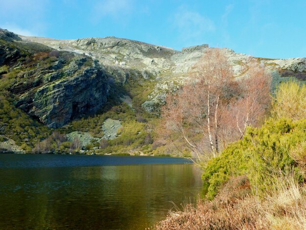 Un lago de montaña con una montaña al fondo.