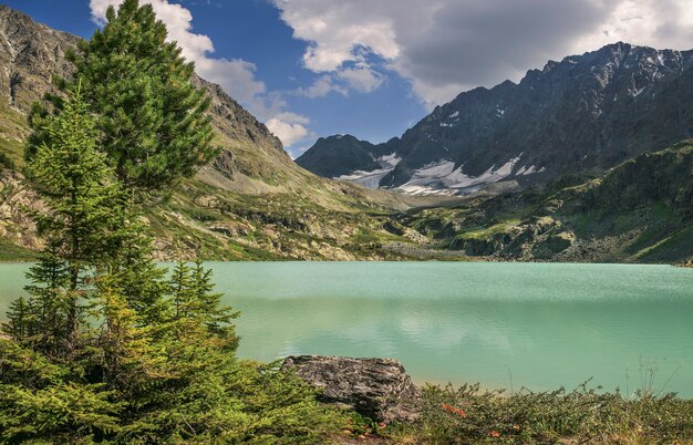 Lago de montaña en las noches de verano, cielo nublado