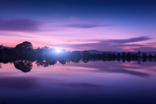 Lago de montaña con salida de luna en la noche Paisaje nocturno