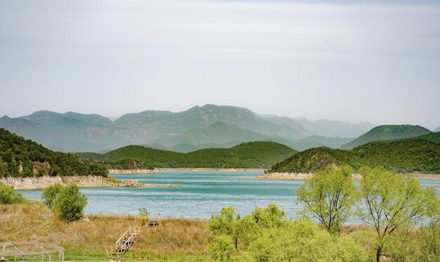 Un lago con montañas al fondo.