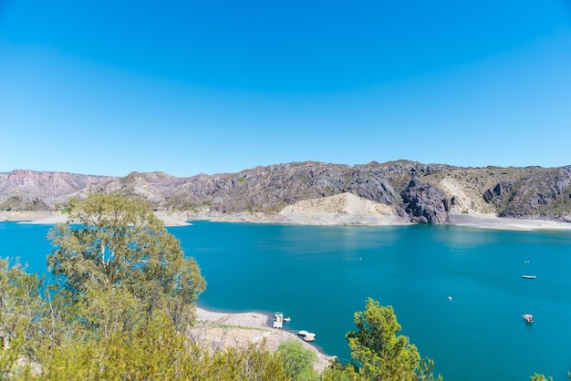 Un lago en las montañas con árboles y agua azul.