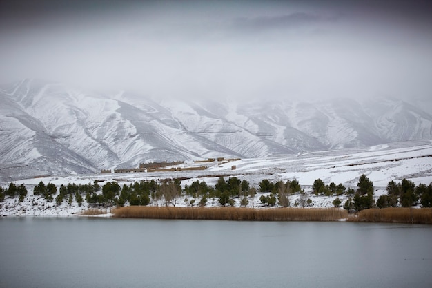 Lago con montañas del Atlas cubiertas de nieve en la parte de atrás