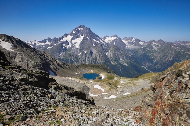 Lago montañas del Cáucaso en verano, el derretimiento de la cresta glaciar Arkhyz Sofia lago. Hermosas montañas altas de Rusia, agua helada clara. Verano en las montañas, caminata. Fabuloso paisaje y cielo azul