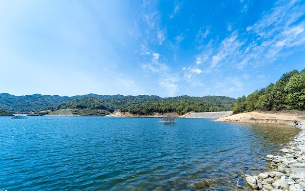 Un lago en las montañas con un cielo azul y el lago embalse Dhap en Katmandú Nepal