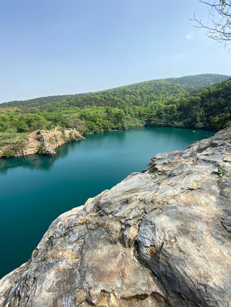 Foto un lago en las montañas con un lago azul al fondo