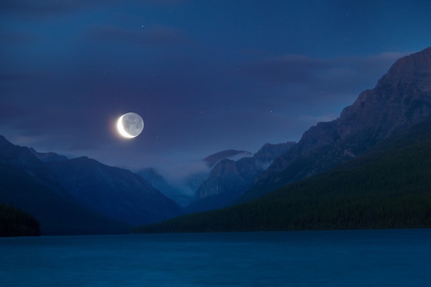 Lago nas montanhas à noite sob a luz da lua