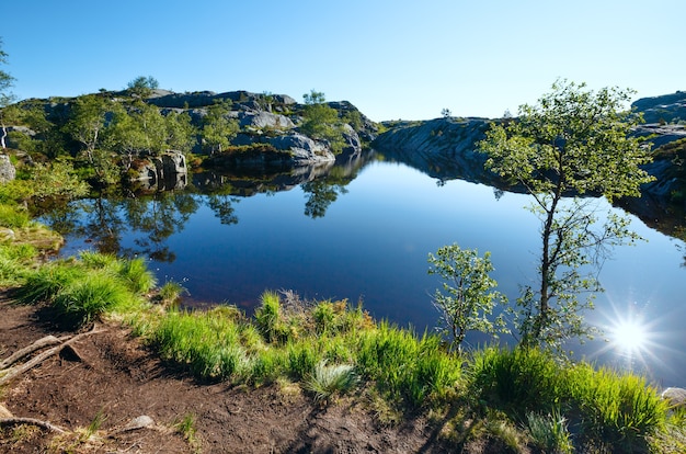 Lago de Noruega de montaña pequeña azul profundo con reflejo de sol