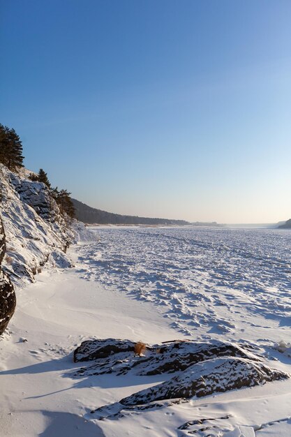 lago o río congelado en invierno. Cerca del bosque y las montañas en la nieve. Hermosos paisajes de invierno