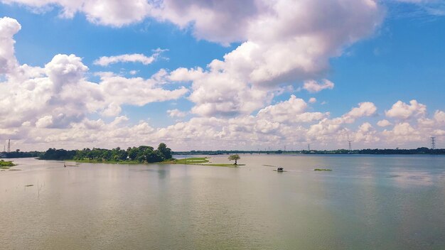 Lago con plantas y cielo azul con nubes.