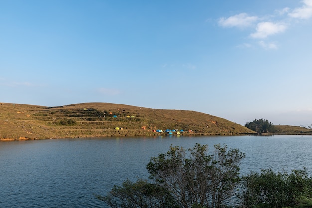 En el lago de la pradera, la gente instaló tiendas de campaña junto al lago;