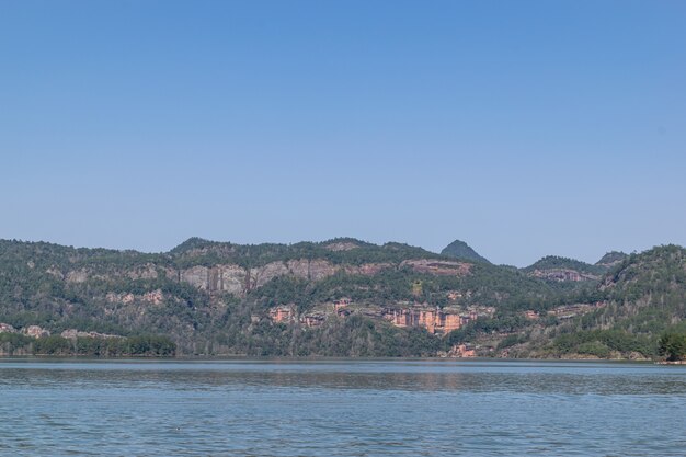 El lago refleja las montañas de la forma de relieve de Danxia