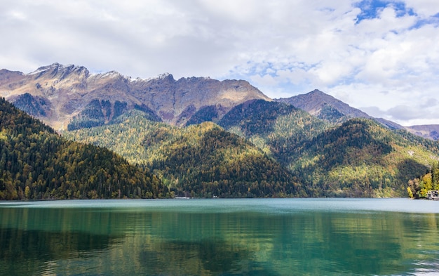 Lago Ritsa en Abjasia en otoño, vista al lago con bosque de otoño en el fondo