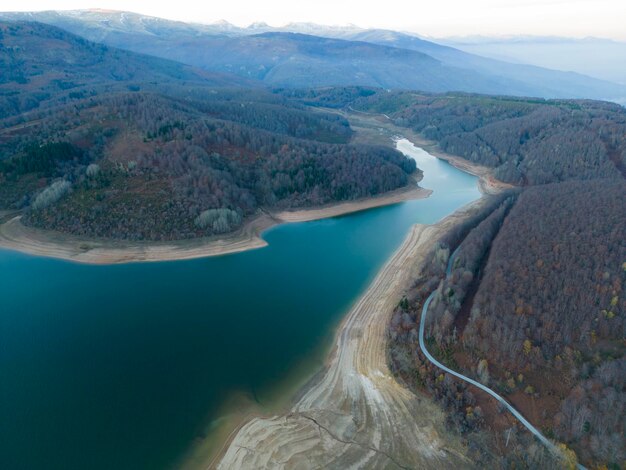 Un lago rodeado de montañas carretera cerca del bosque marrón de Mavrovo parque nacional Macedonia