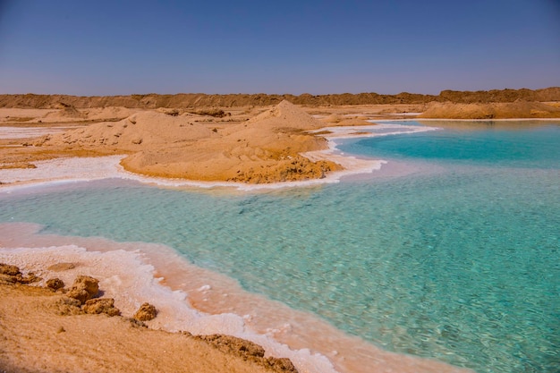 Lago salgado com água turquesa e sal branco na costa perto do oásis de Siwa, Egito