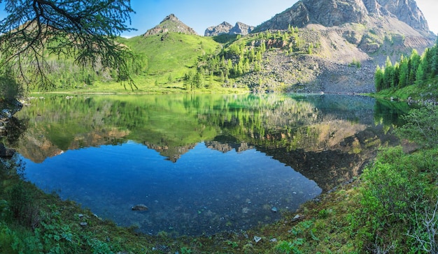 Lago salvaje en las montañas de Altai en una mañana, verdes de verano, reflejo pintoresco