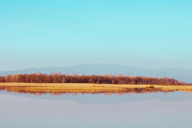 Un lago sereno con reflejos y fondo de montaña perfecto para el espacio de copia