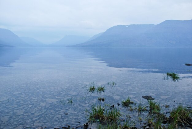 El lago de la tarde en la niebla azul.