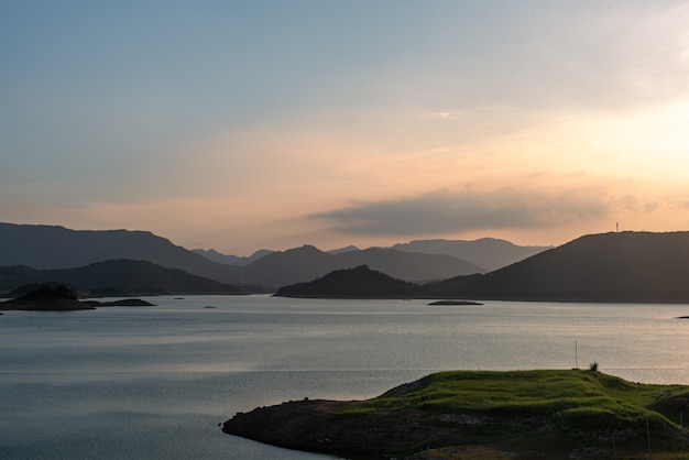 El lago de la tarde reflejaba las montañas y el cielo a ambos lados;