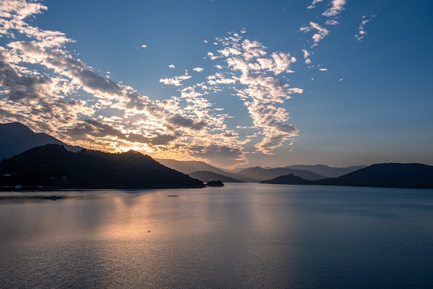 El lago de la tarde reflejaba el resplandor del atardecer y las montañas.