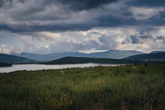 Un lago en el valle entre las montañas antes de que llueva