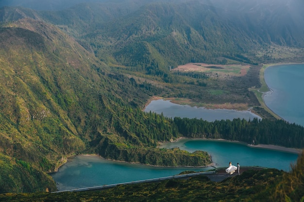 Lagoa do Fogo um lago vulcânico em São Miguel Açores Um jovem casal de terno e vestido caminha por uma bela paisagem