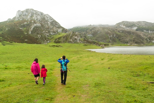 Foto lagos de covadonga con niebla en primavera. turistas de senderismo en el lago enol. asturias, españa