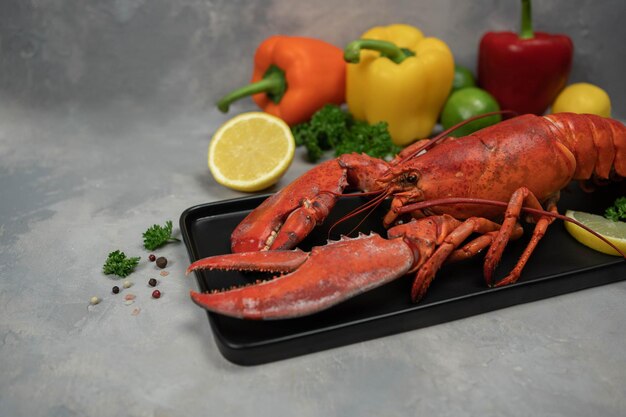 Lagosta decorada com fatias de limão em chapa preta em concreto Frutos do mar frescos Comida de luxo