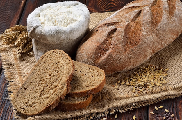 Laib Roggenbrot mit Scheiben auf Sackleinenhintergrund