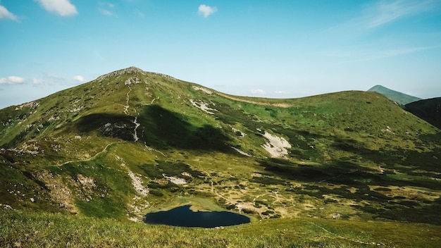 Lake Nesamovite und die umliegende Landschaft vor dem Hintergrund der grünen Berge und des blauen Himmels