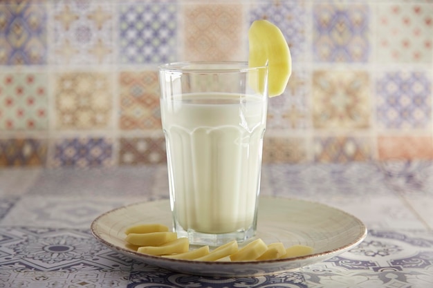 Laktosefreie umweltfreundliche Kartoffelmilch und Kartoffel auf dem Teller auf dem Tisch Alternative milchfreie Milch Fliese klassischen Hintergrund Kopierbereich