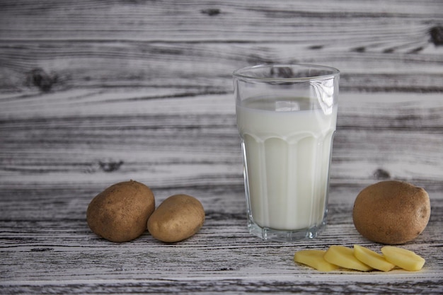 Laktosefreie umweltfreundliche Kartoffelmilch und Kartoffel auf dem Teller auf dem Tisch Alternative milchfreie Milch Fliese klassischen Hintergrund Kopierbereich