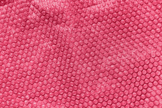 Lámina de burbujas transparente para envolver el fondo de textura en el color de moda del año 2023 Viva Magenta