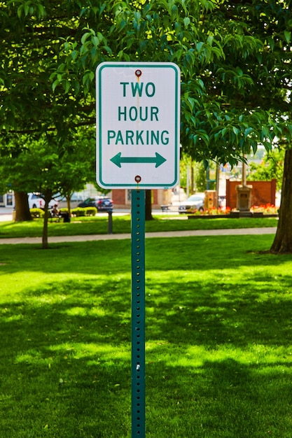 Lámina de estacionamiento verde de dos horas frente al parque en verano