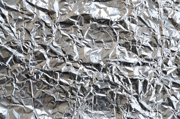 Foto láminas arrugadas finas de fondo de lámina de aluminio estañado triturado con superficie arrugada brillante para textura