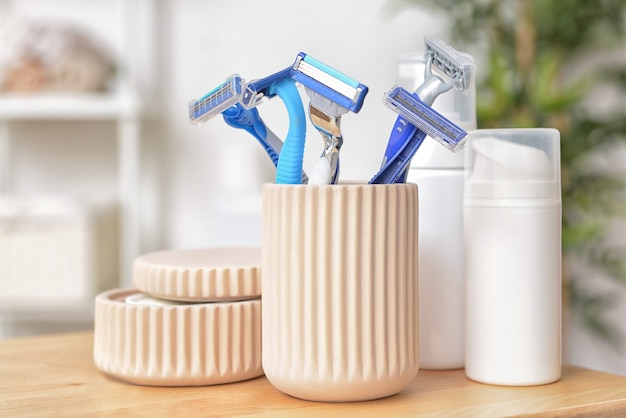 Foto lâminas para depilação com cosméticos na mesa do banheiro