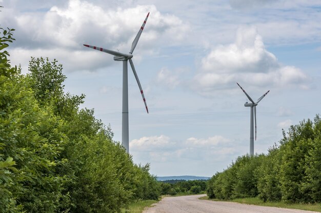 Lâminas rotativas de uma hélice de moinho de vento no fundo do céu azul geração de energia eólica energia verde pura