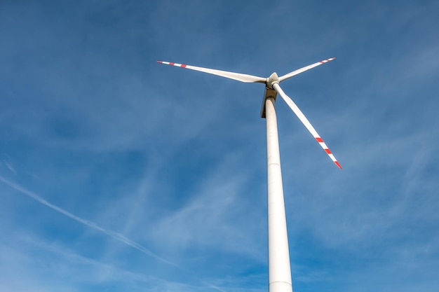 Lâminas rotativas de uma hélice de moinho de vento no fundo do céu azul Geração de energia eólica Energia verde pura