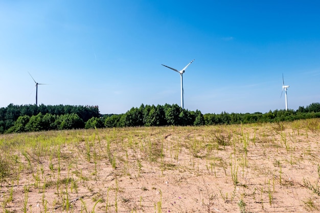 Lâminas rotativas de uma hélice de moinho de vento no fundo do céu azul geração de energia eólica energia verde pura