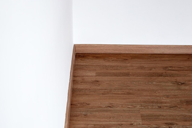 Laminat-Holzboden mit leerer weißer Wand