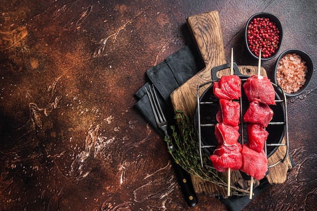 Lamm Schaschlik Rohes Fleisch Spieße mit Kräutern auf dem Grill Dunkler Hintergrund Ansicht von oben Kopieren Sie Platz