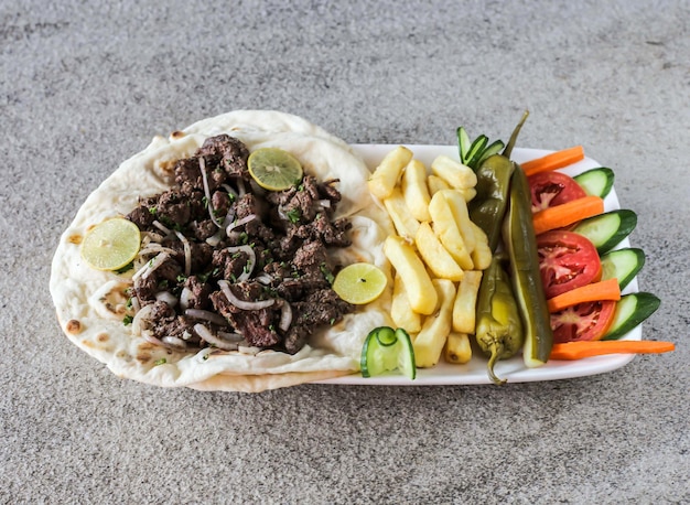 Lamm-Shawarma-Platte mit Pommes Frites und Salat, serviert in einer Schüssel, isoliert auf dem Hintergrund, Draufsicht auf Fast Food